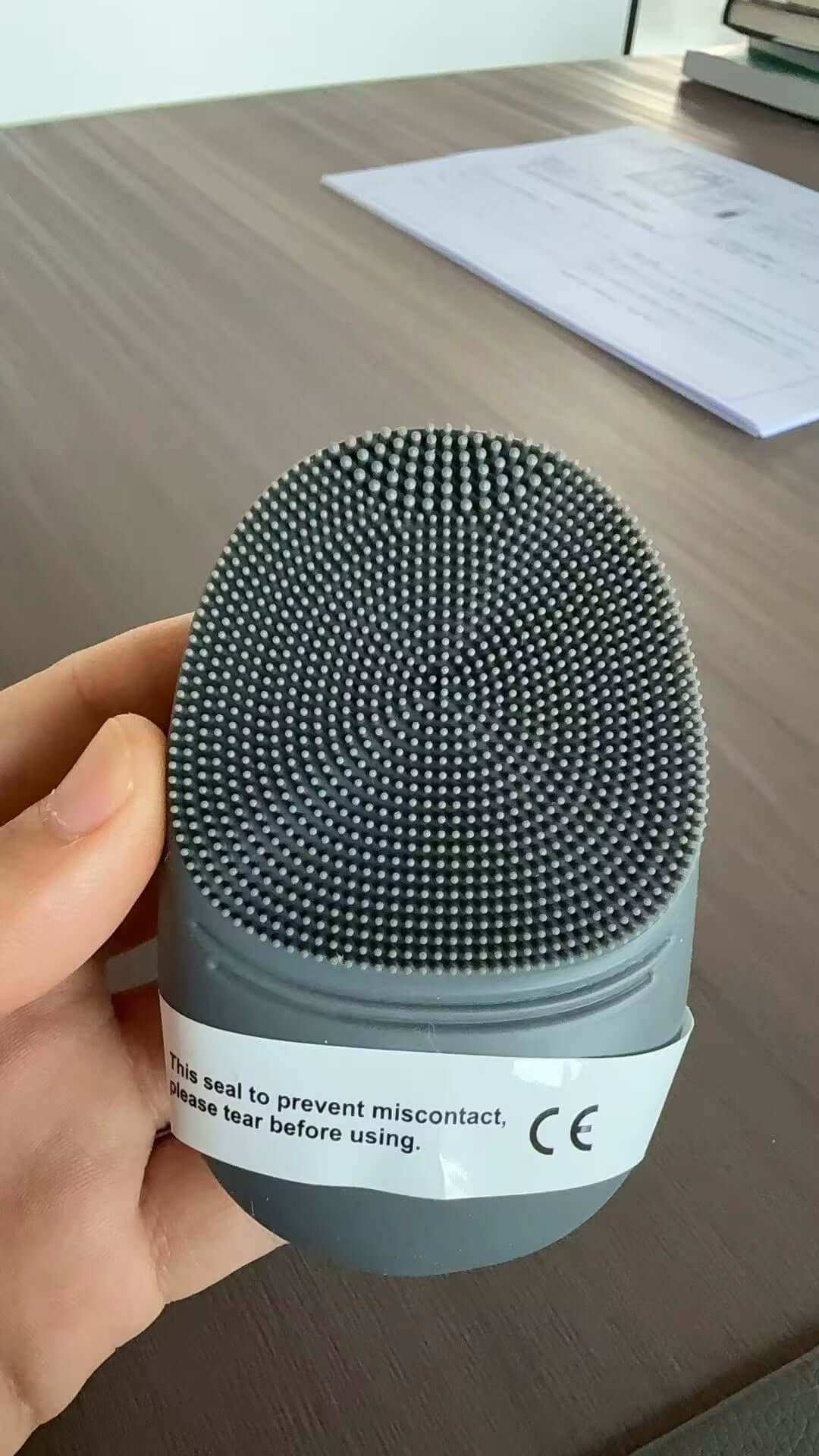 Light grey silicone sonic facial cleanser brush for deep skin cleansing and exfoliation